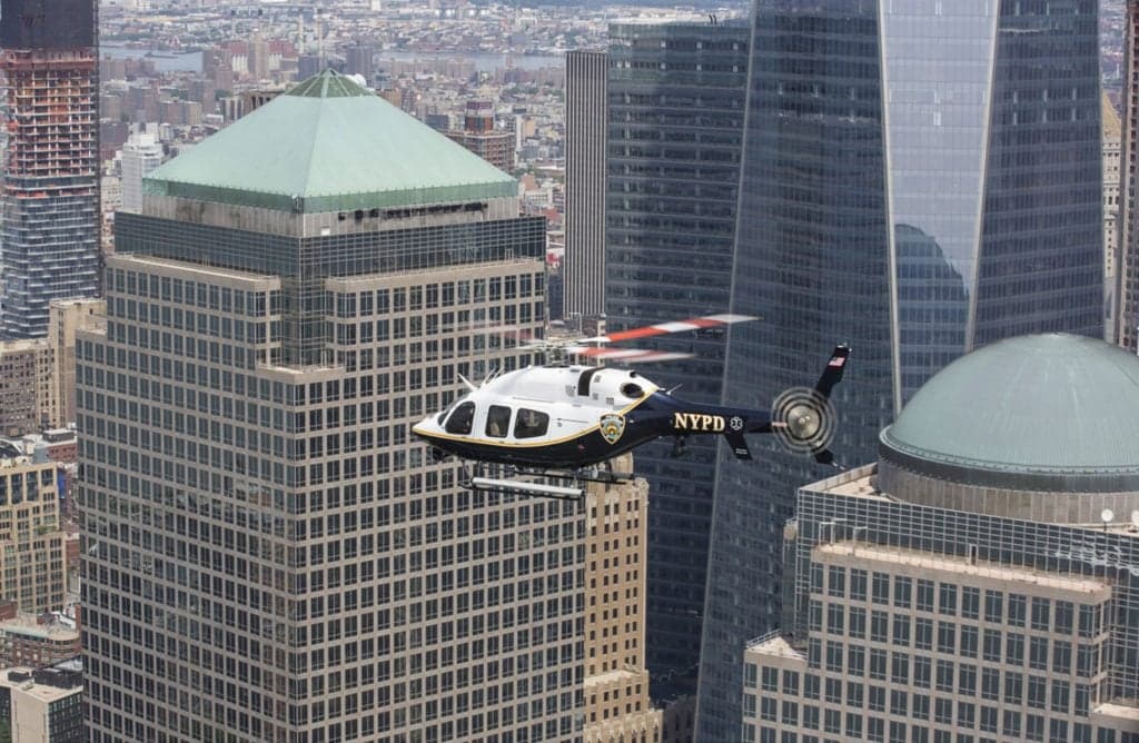 An NYPD helicopter flies in front of the New York City skyline.