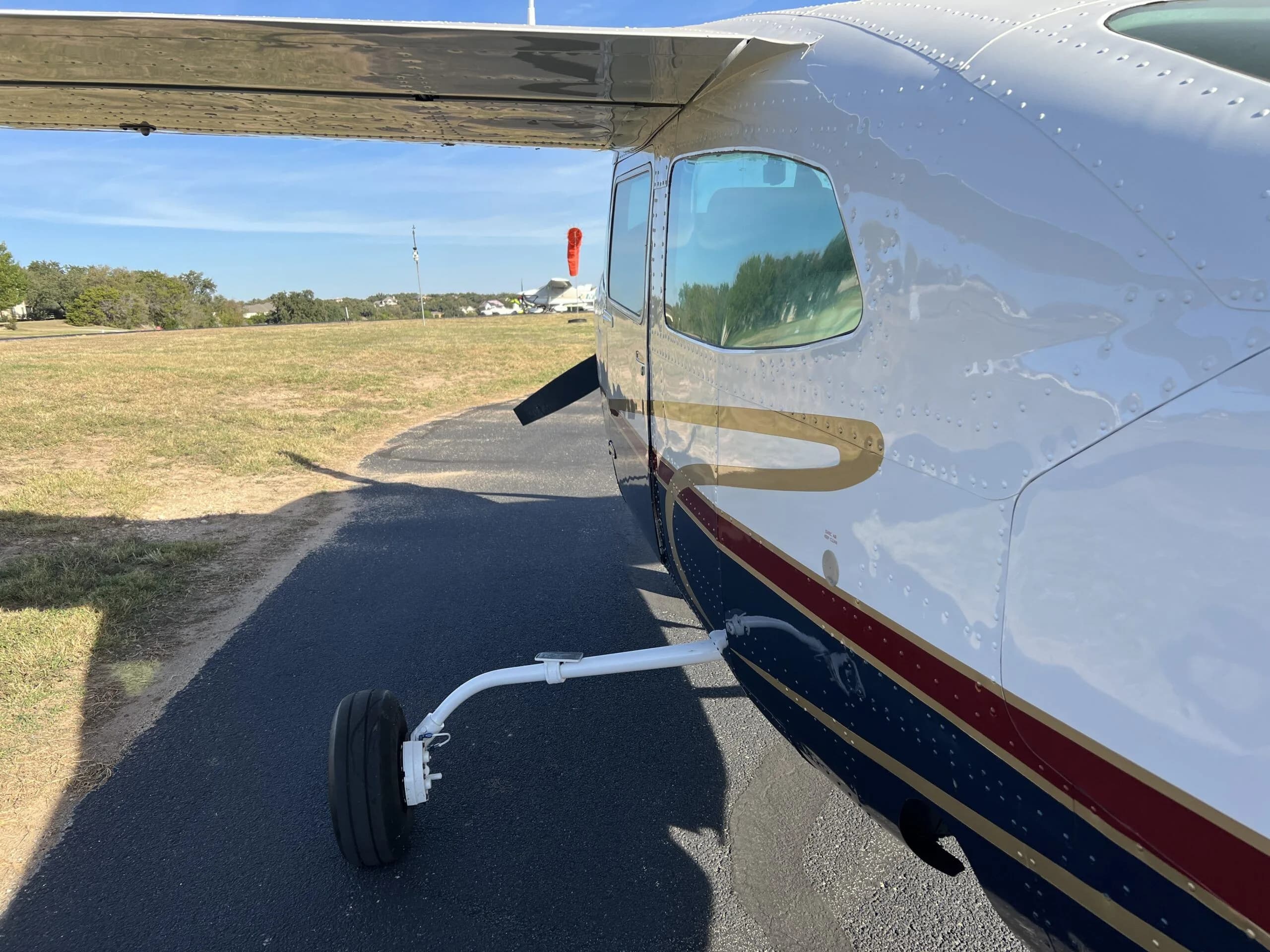 A close-up of the main landing gear and the riveted fuselage of the Cessna 210, N58MA.
