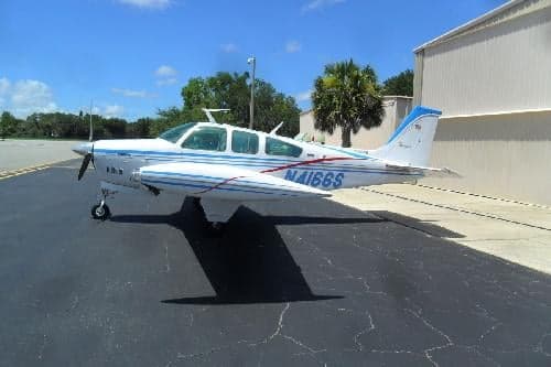 Side view of a Beechcraft Bonanza N4166S on the ground.