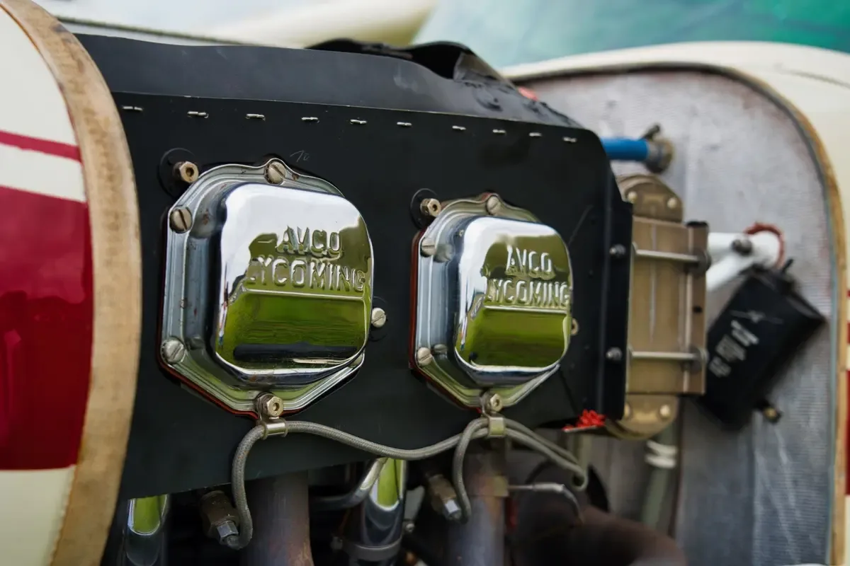 A close-up view of the engine of a small aircraft, showing two chrome "AVCO LYCOMING" valve covers.