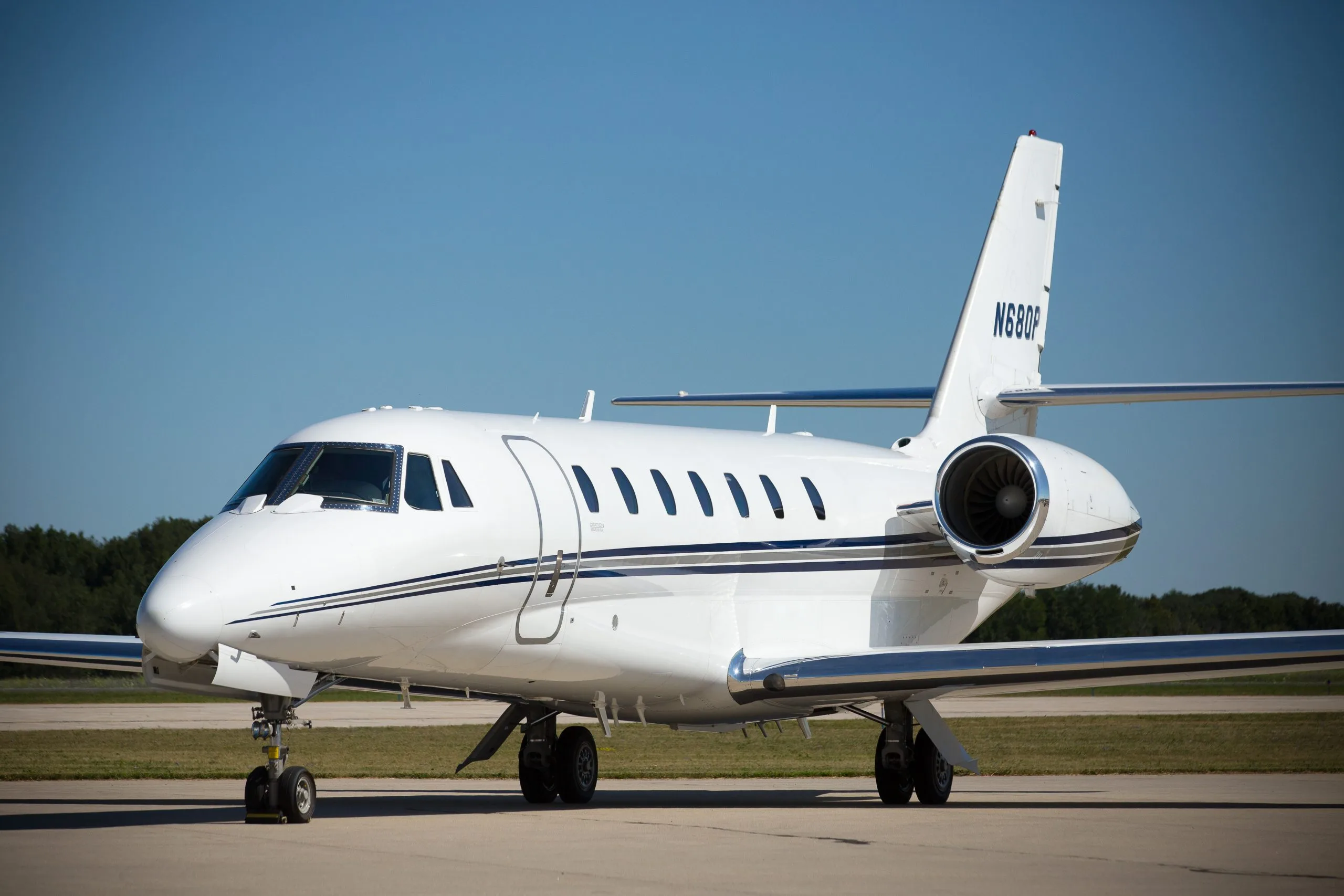 A white aircraft with tail number N680P parked on the tarmac.