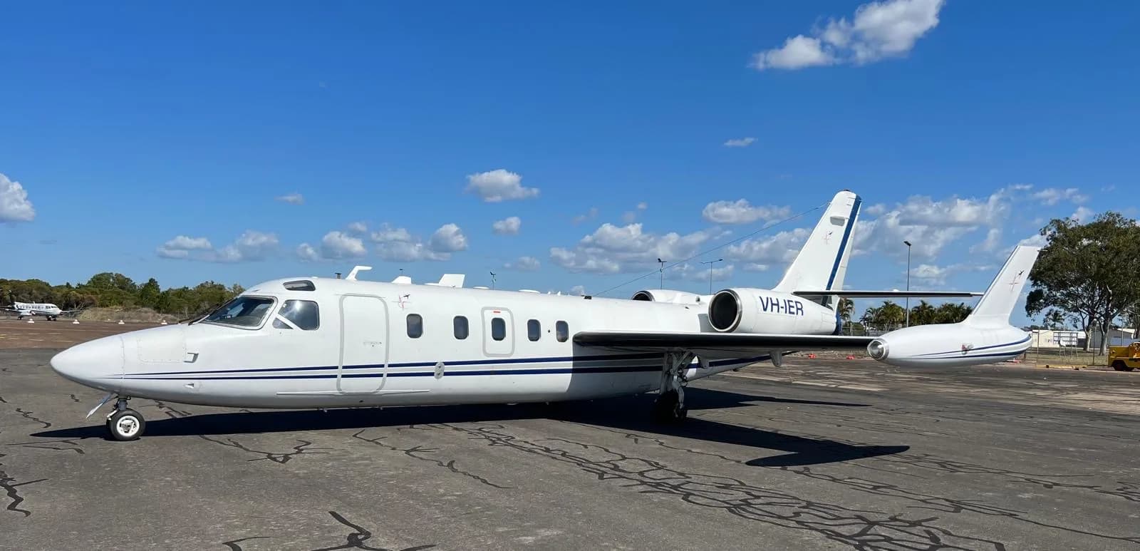 Side view of the VH-IER aircraft on the tarmac under a blue sky.