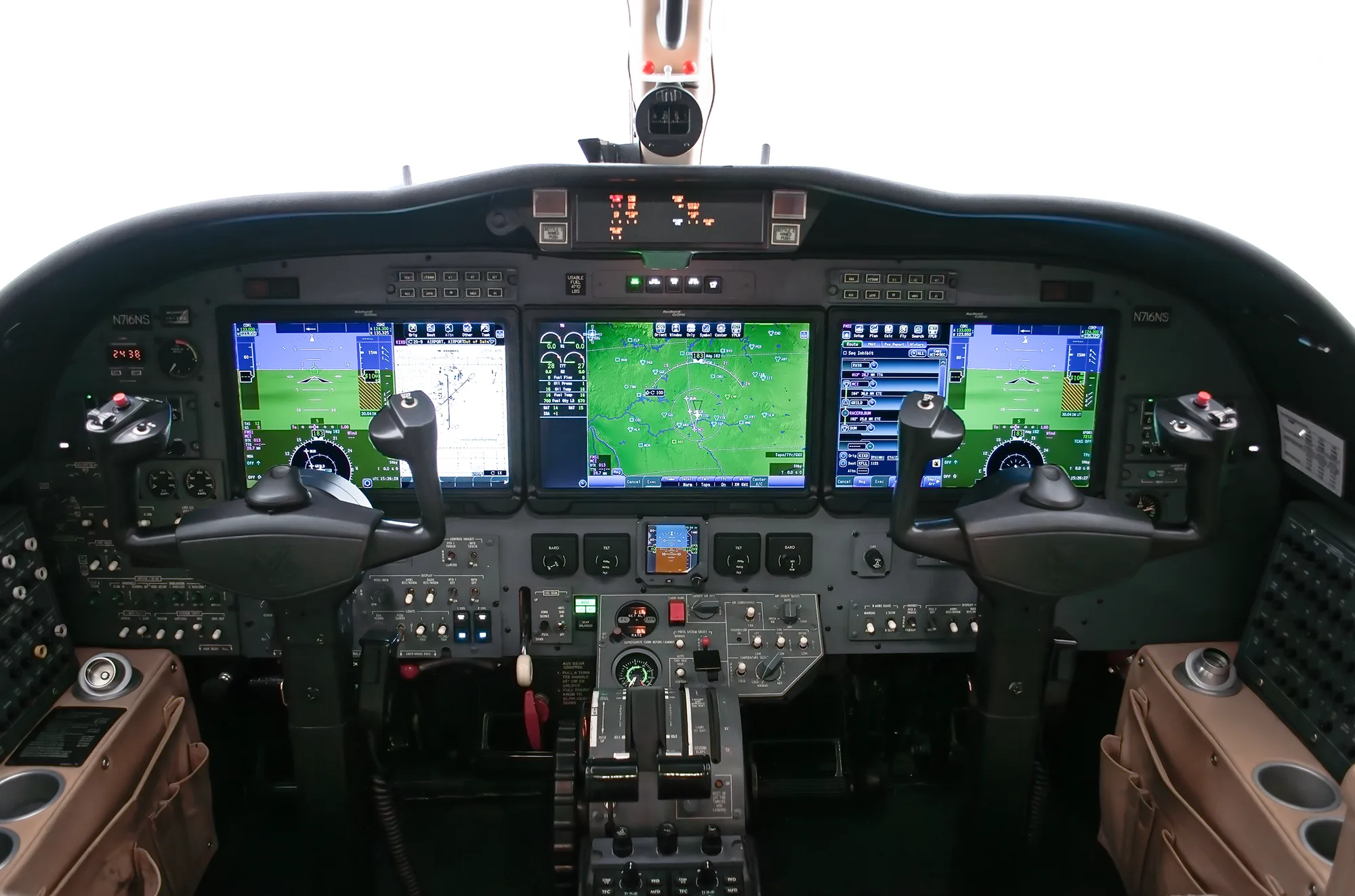 The modern glass cockpit of a business jet, featuring multiple large display screens and control yokes.