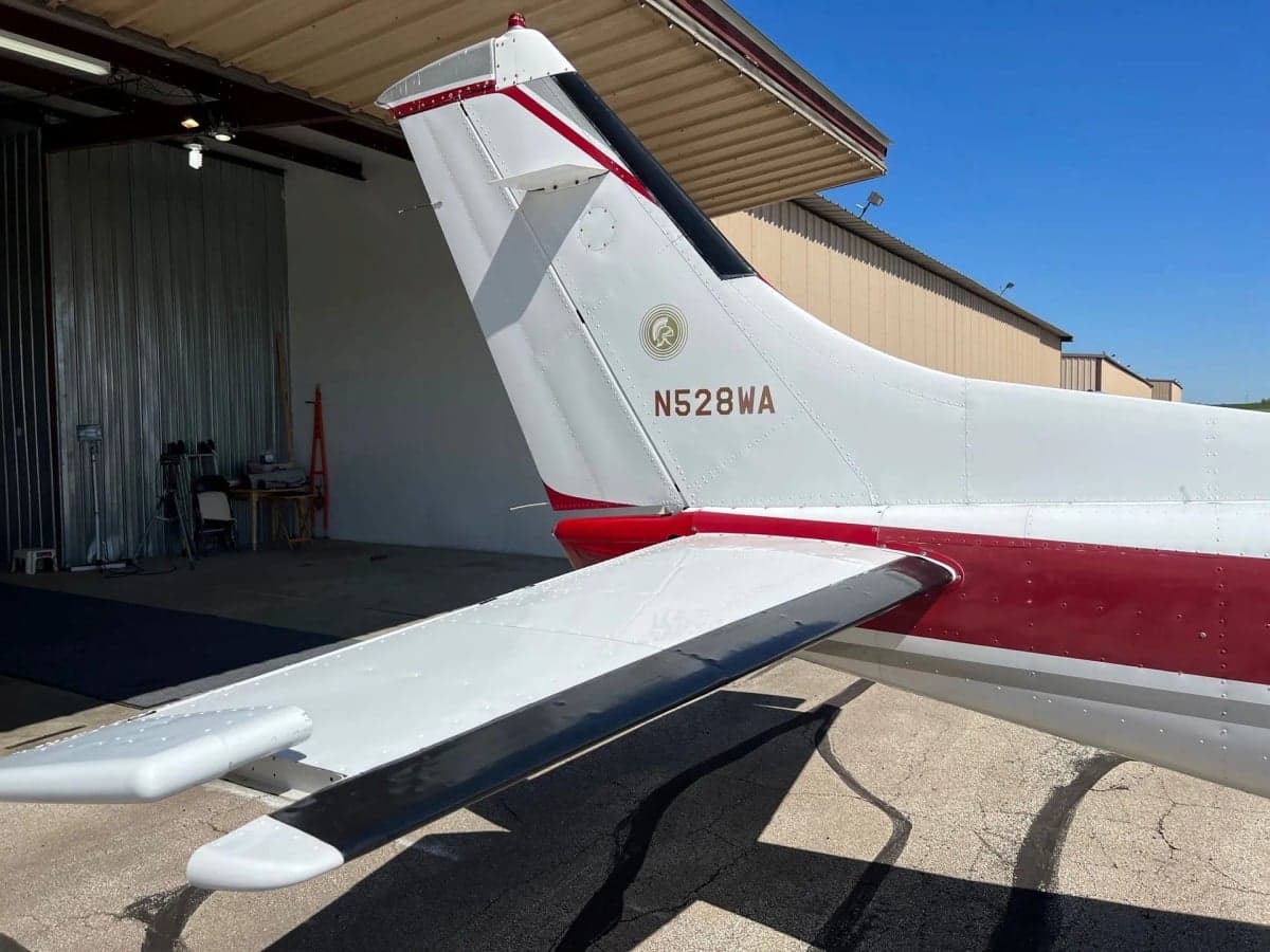 Rear view of the tail section of a red and white aircraft, registration N528WA, showing the horizontal stabilizer.