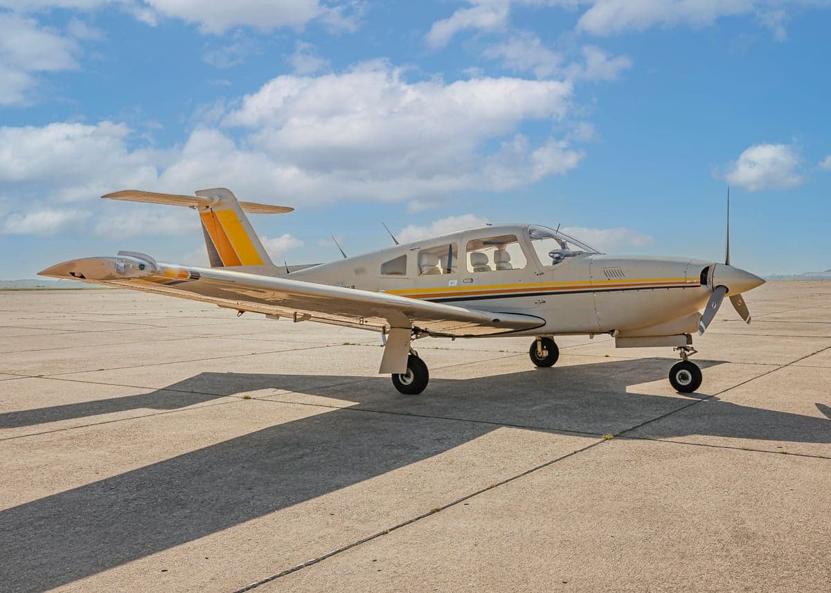 Piper Arrow II with a tan and orange paint scheme parked on the tarmac.
