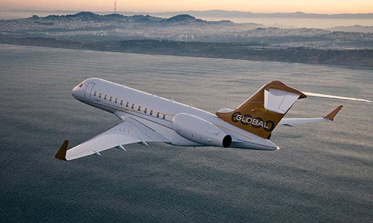 Bombardier Global Express flying over the ocean.