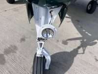 A close-up of a Beechcraft Bonanza with a white and green paint scheme.