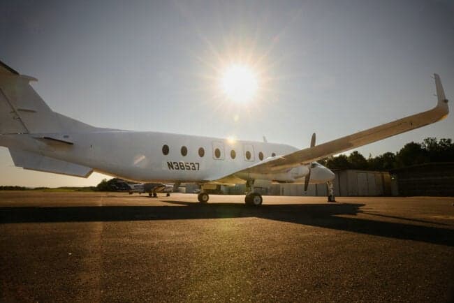 The propeller and nose of a white turboprop aircraft.