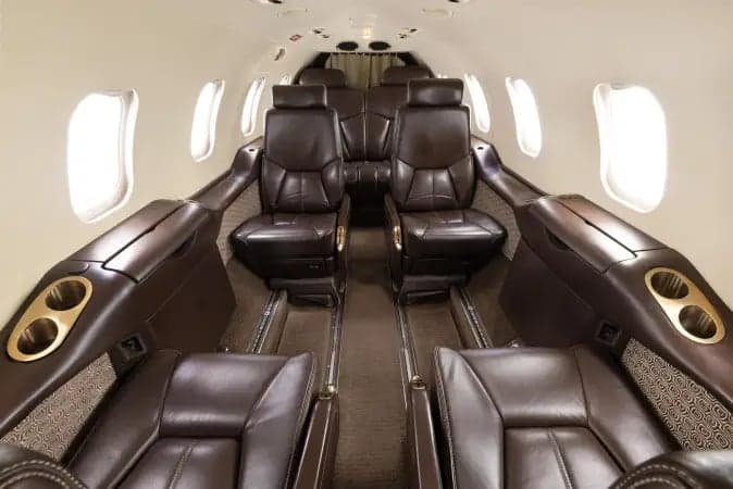Interior view of the Learjet 45XR cabin with a cabinet and seat.