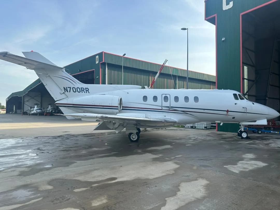 A Hawker 400XP aircraft with registration N700RR is parked outside a hangar.