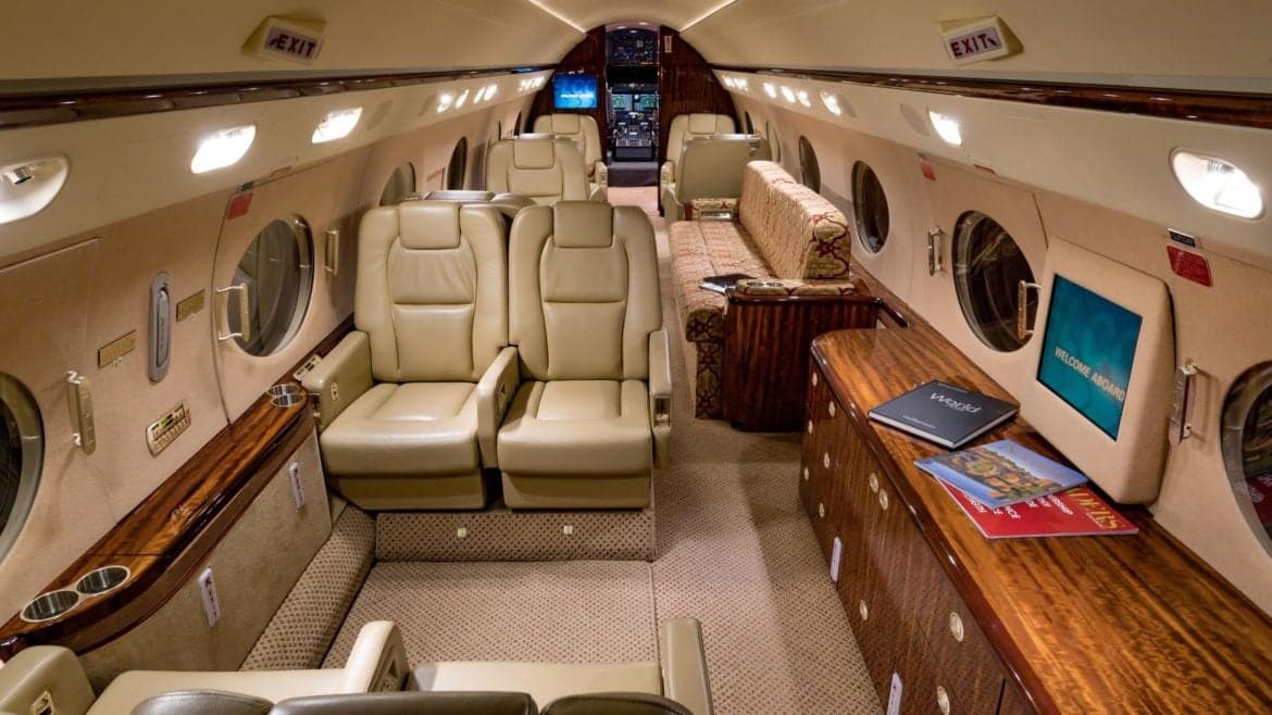 The interior of the aircraft features leather seats and wood accents.