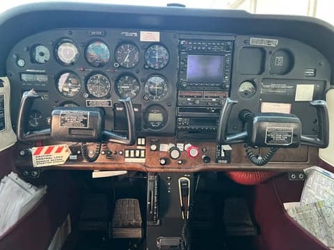 The cockpit of the Cessna 172, N97055, showing the instrument panel, yokes, and avionics.