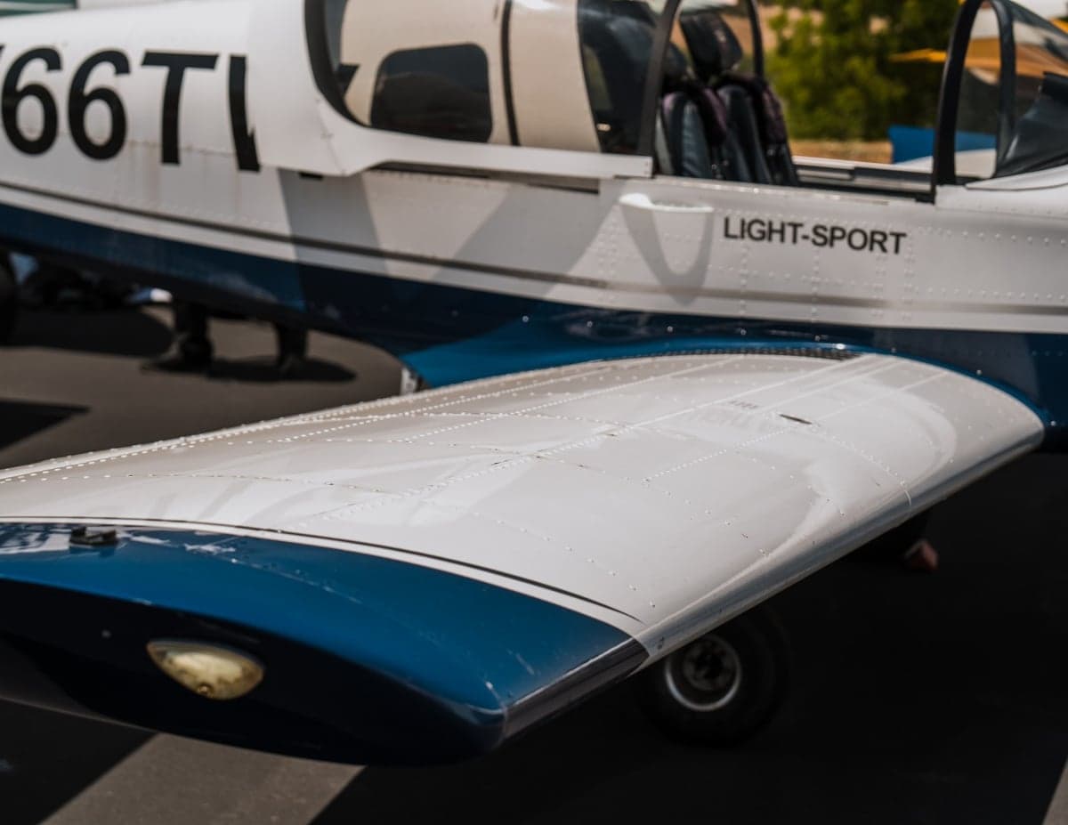 Close up of the wing and fuselage of the Sling LSA aircraft, with the cockpit visible in the background.