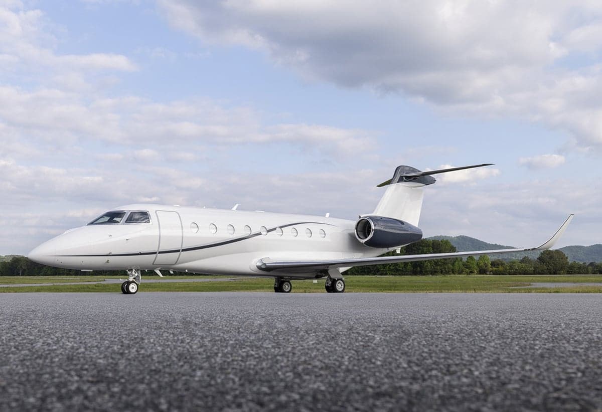 A white and gray jet aircraft is parked on the tarmac.