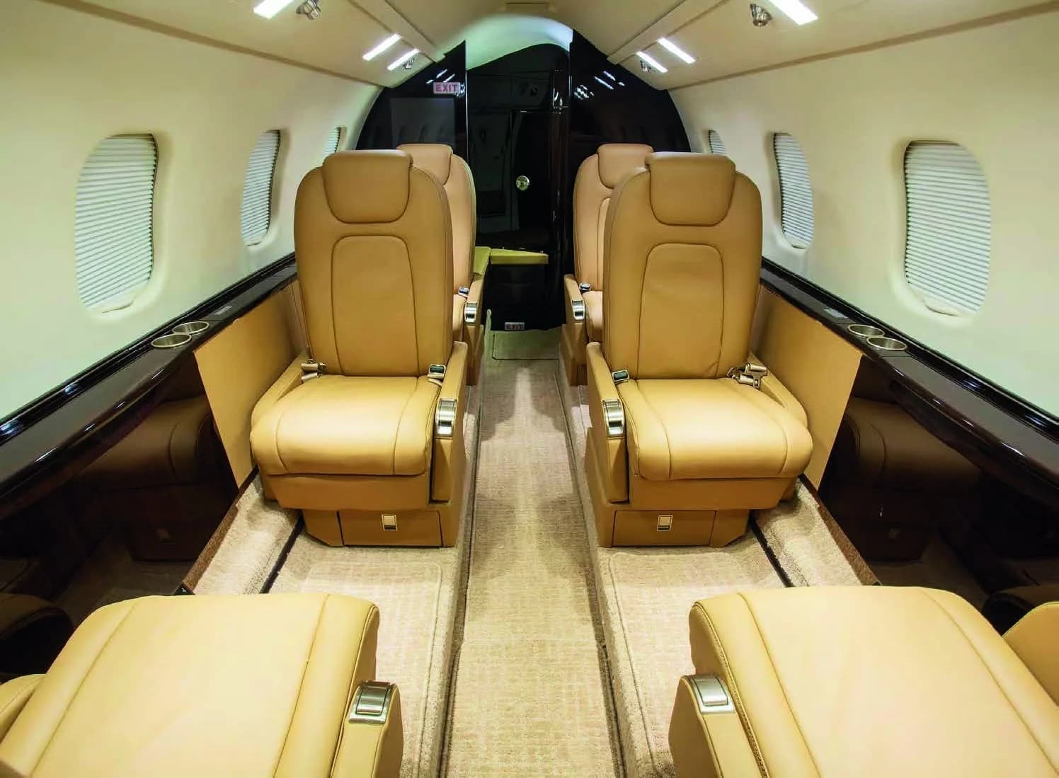 The full cabin interior of a Learjet 75, with tan leather seats and dark wood accents.