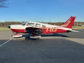 A Piper PA-28 Cherokee with registration D-EKJF, featuring a white and red paint scheme.