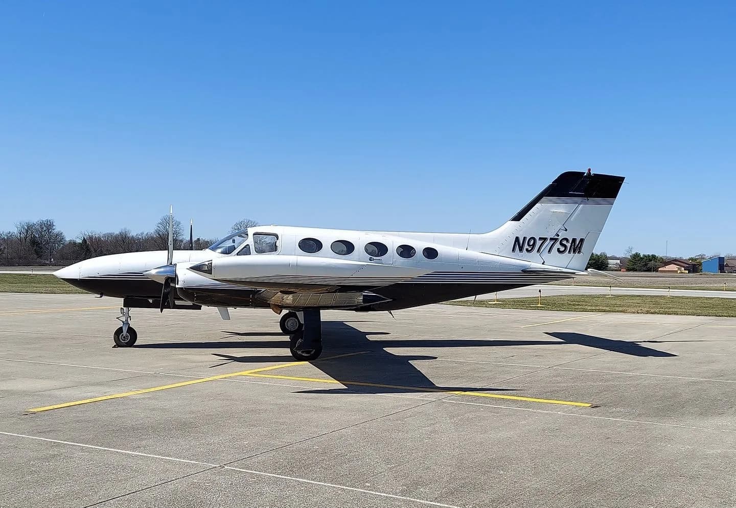 A Cessna 414 aircraft with registration N977SM parked on the tarmac.