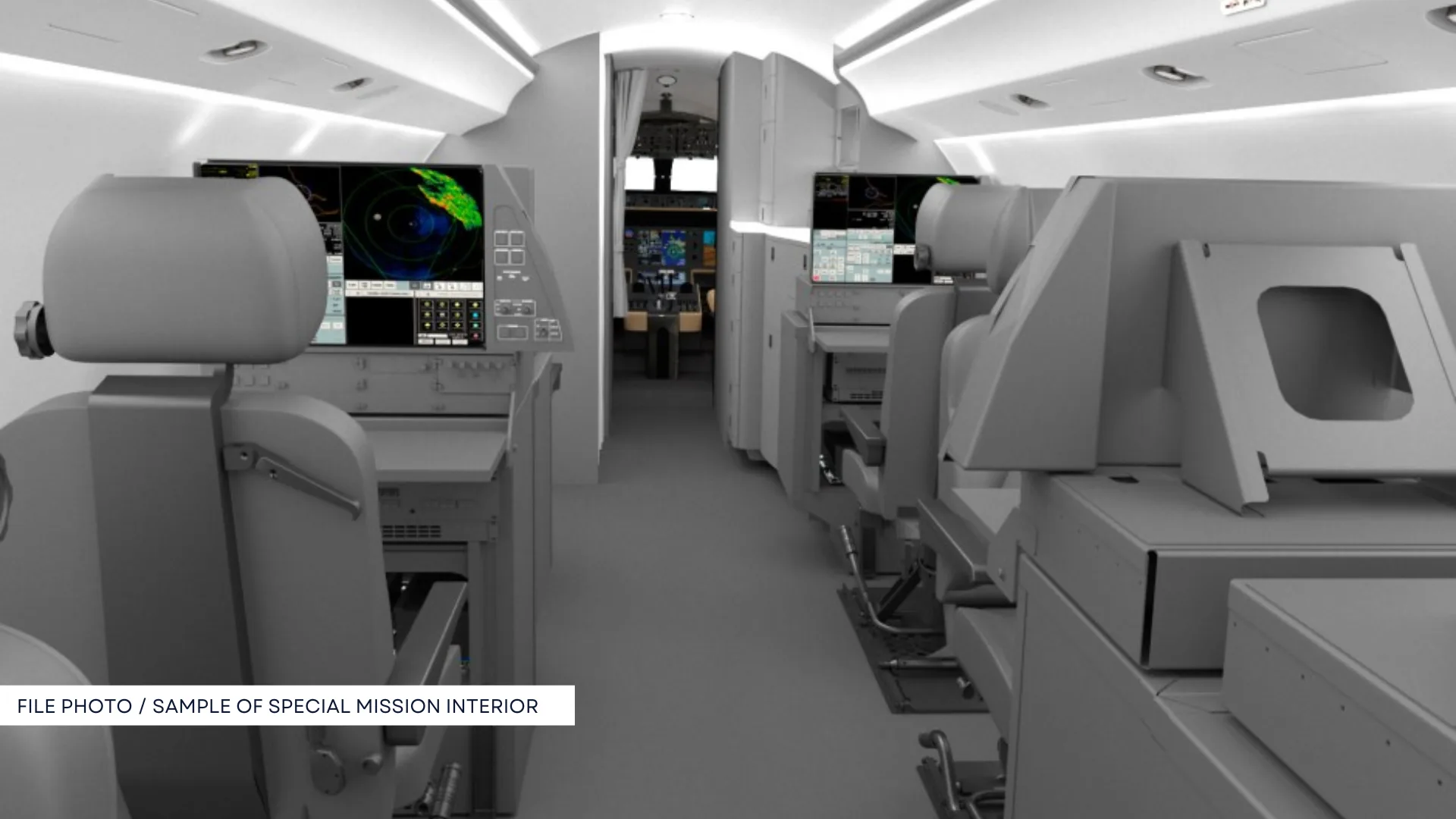 A specialized aircraft interior configured for special missions, featuring multiple screens and equipment racks.