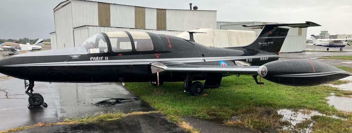 Side view of a Fouga CM.170 Magister, also known as a Paris II, parked on the grass.