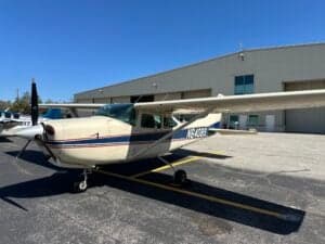 A Cessna 182 Skylane, registration N6408S, parked on the tarmac in front of a hangar.