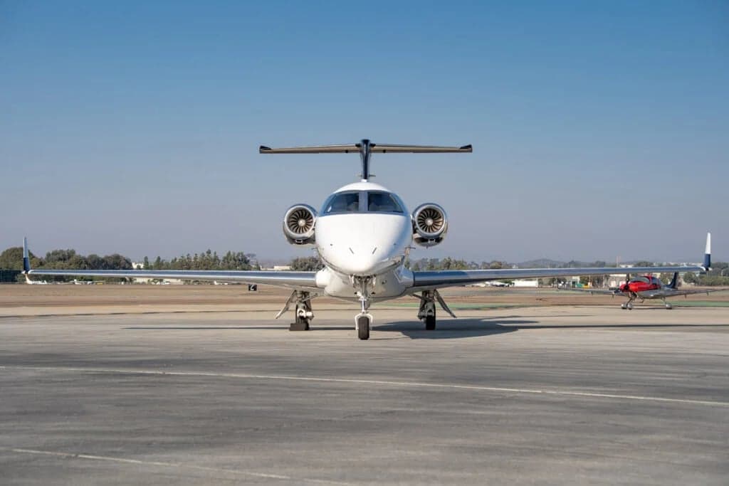Front view of a Phenom 300 aircraft parked on the tarmac.