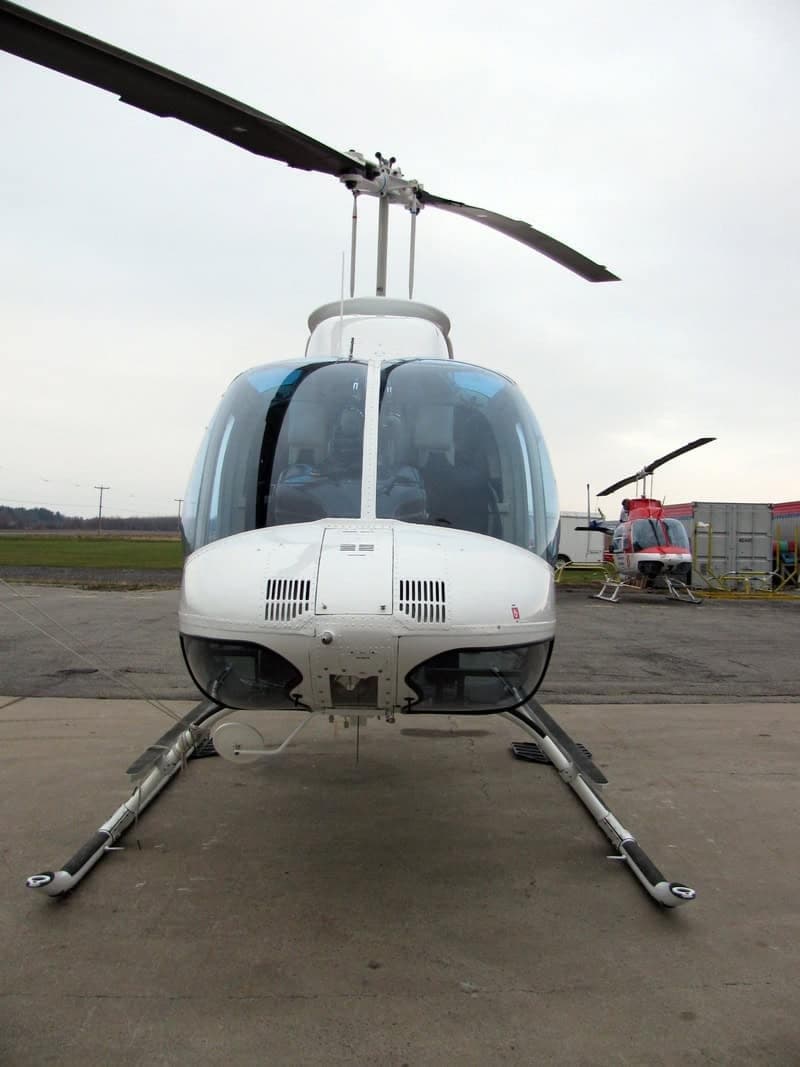 Front view of a white Bell 407 helicopter on the tarmac.