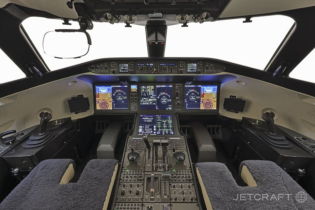 The cockpit of an aircraft with multiple displays and controls.