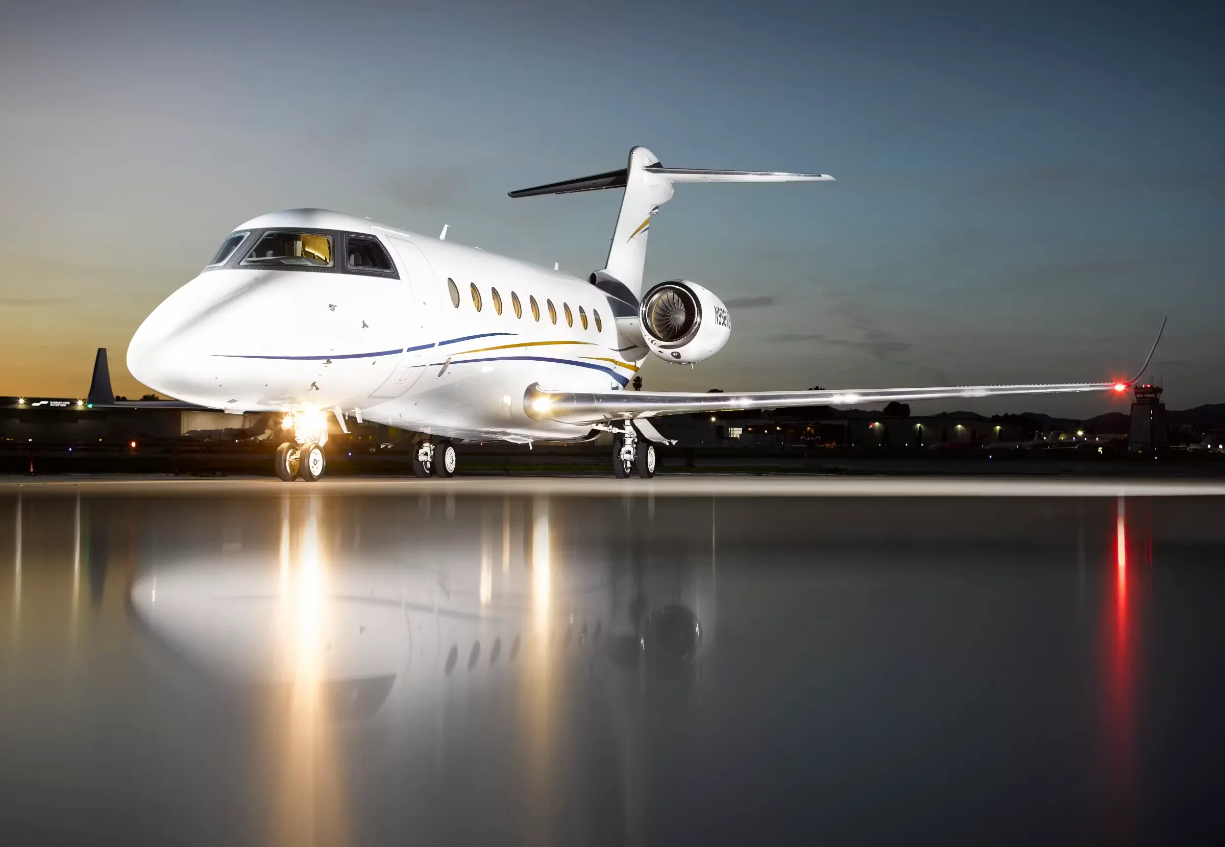A Bombardier Global Express business jet on the tarmac at dusk.