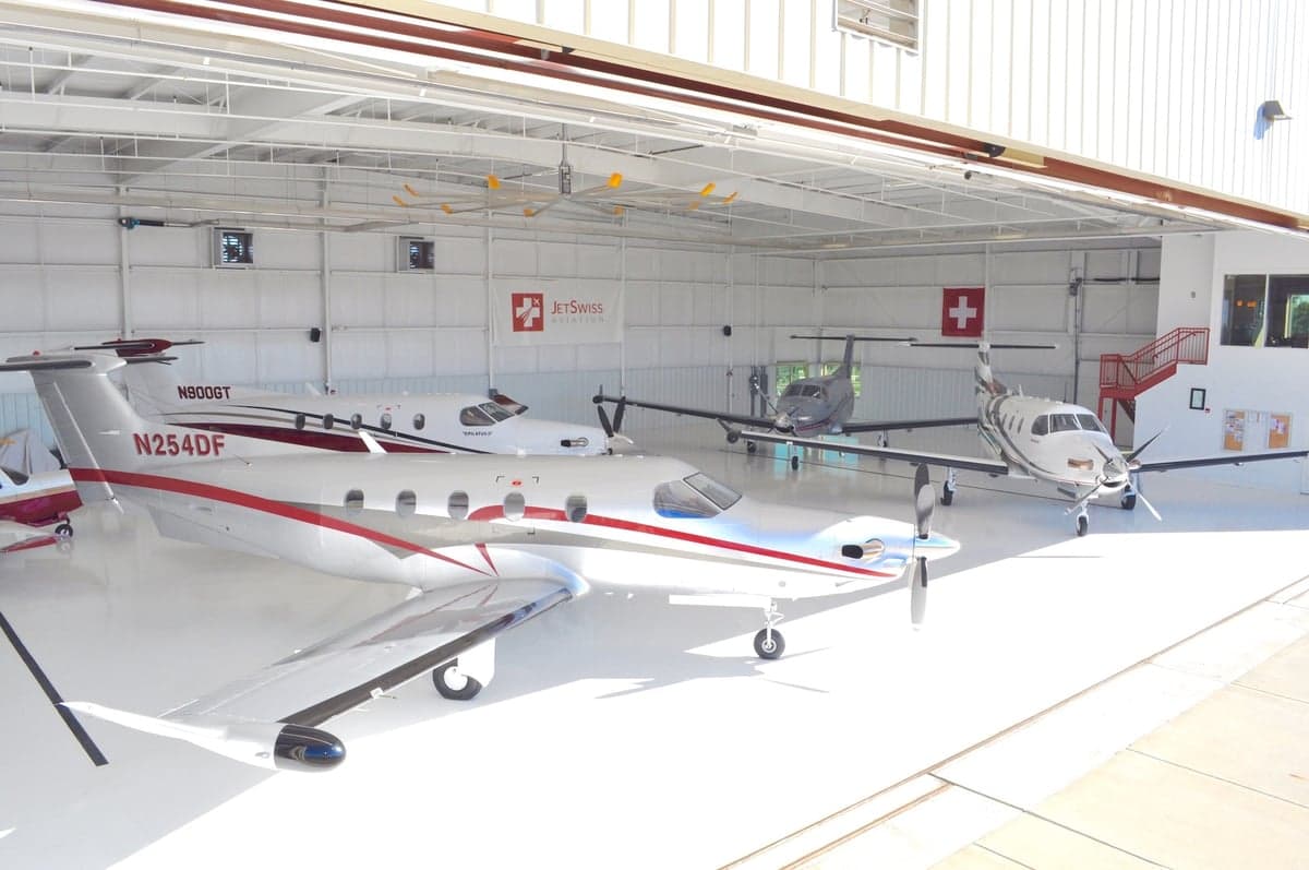 Several Pilatus PC-12 aircraft parked inside a hangar.