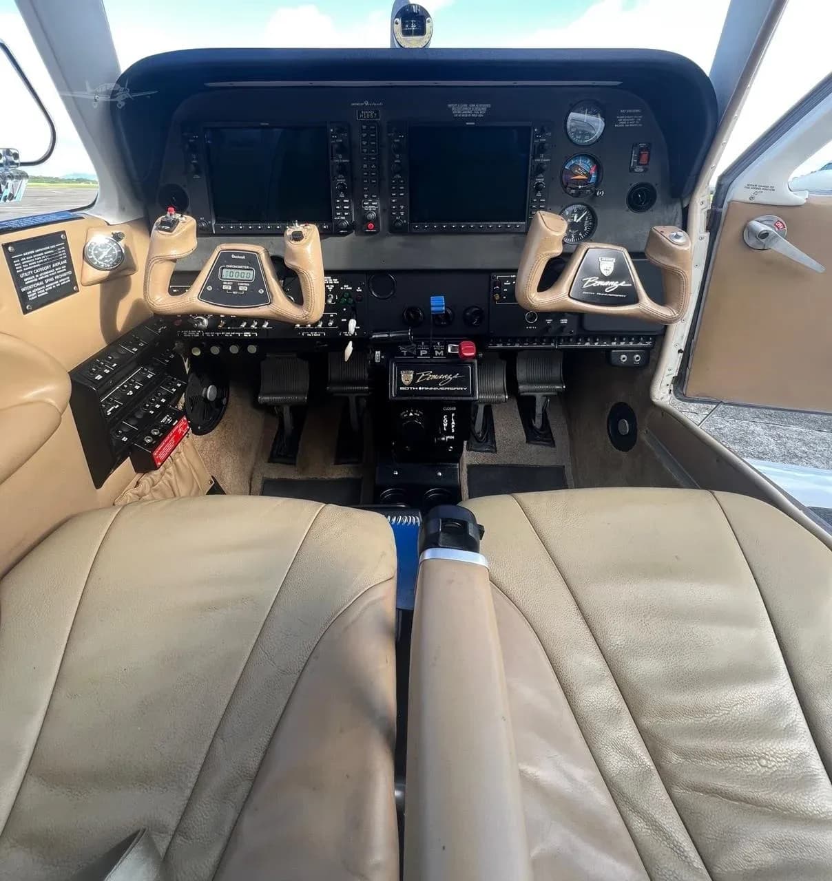 View of the cockpit with tan seats and dual yokes.