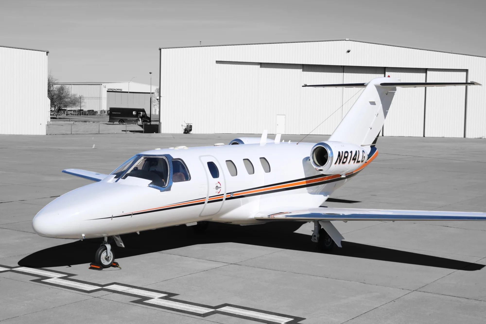 Cessna Citation with orange stripe on the tarmac.
