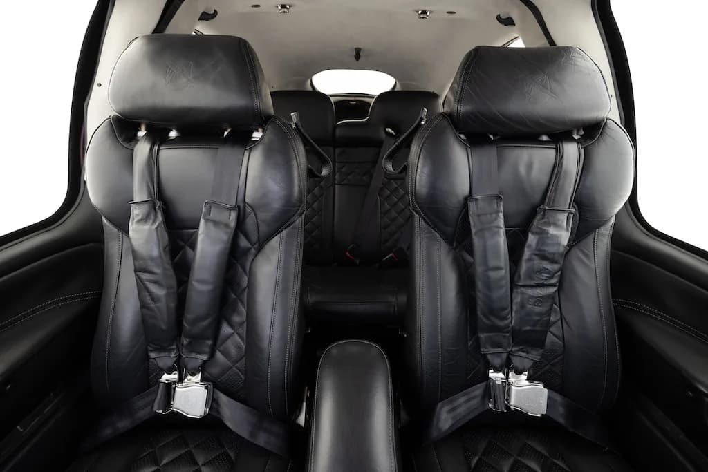 The black leather front seats of the Cirrus SR22 aircraft cabin, featuring quilted stitching.