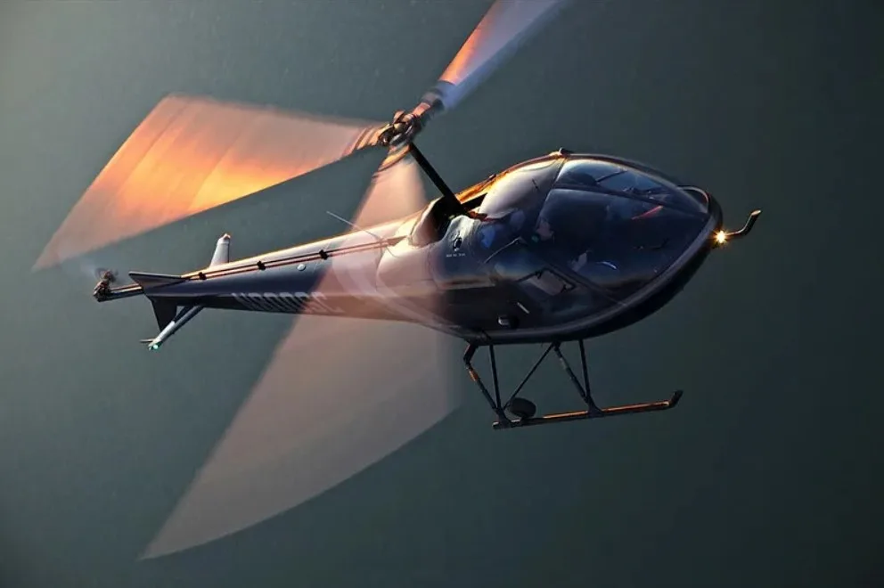 A dark helicopter with spinning rotor blades in flight against a muted background.