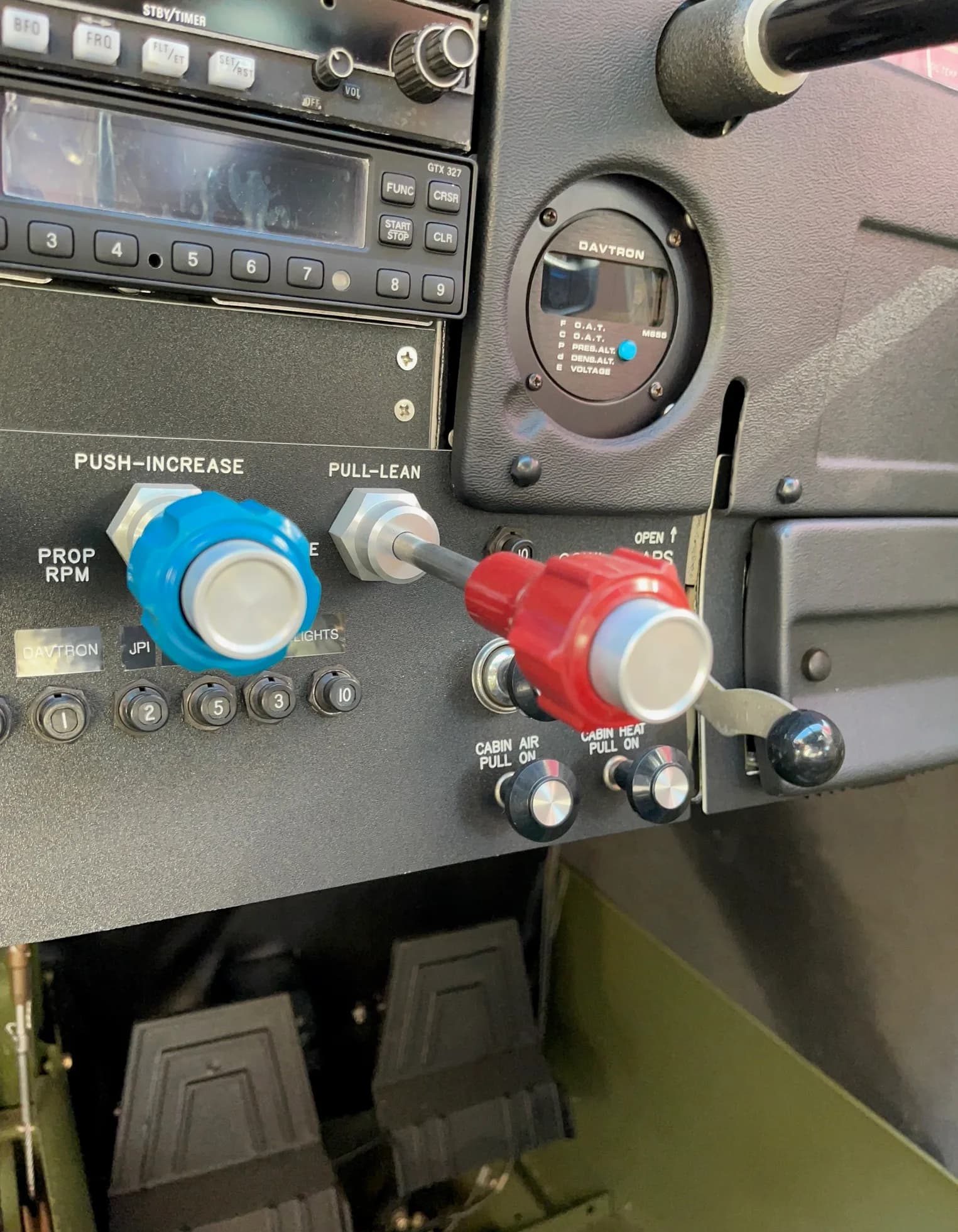 Close-up of the knobs and levers on the instrument panel of an aircraft.