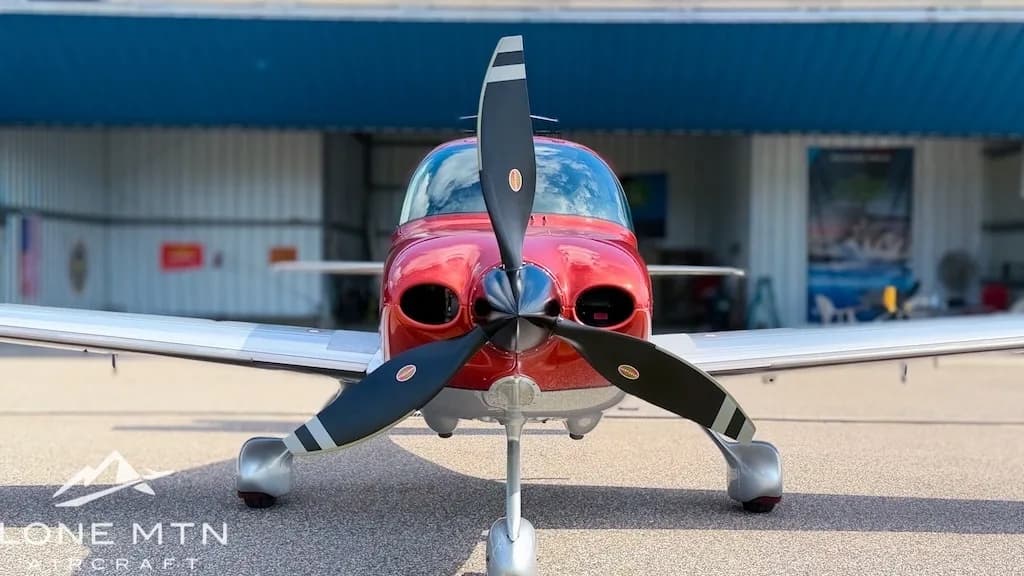 A head-on view of a red and silver Cirrus SR22T aircraft, registration N282AT, with its propeller centered.