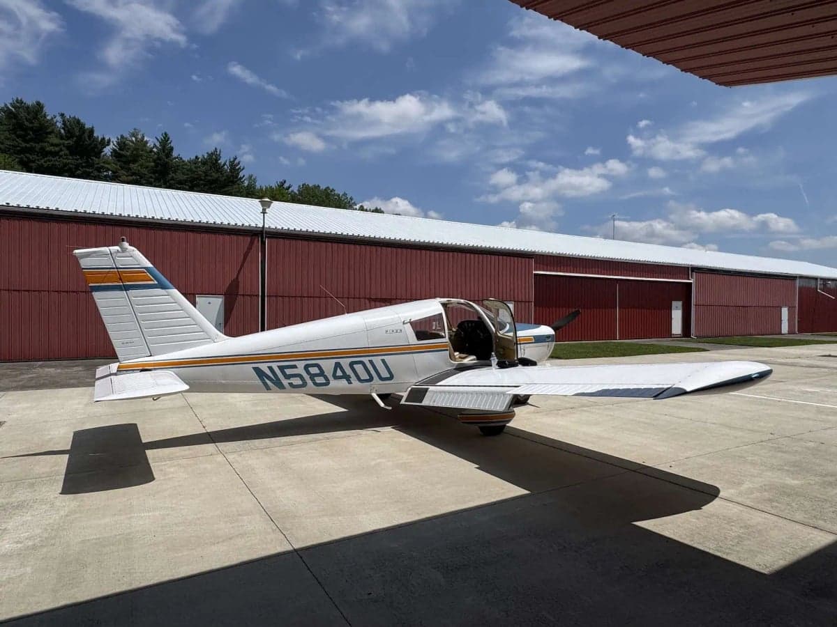 A Piper aircraft with tail number N5840U parked on the tarmac with the door open.