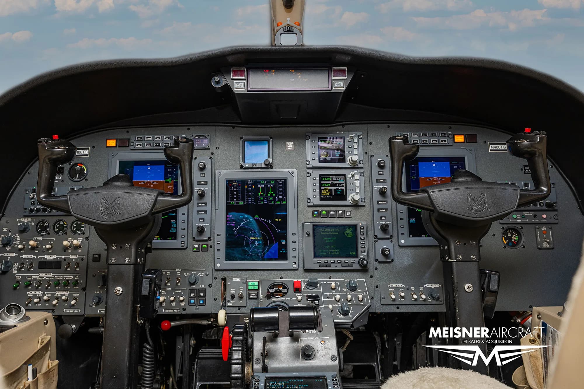 The cockpit of a business jet, showing the instrument panel with multiple digital displays and controls.