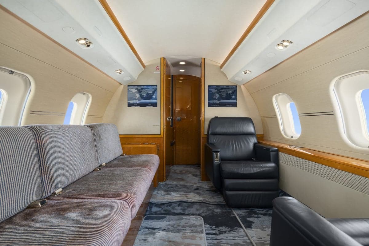 The interior of a Bombardier Global Express with a couch and leather chair.