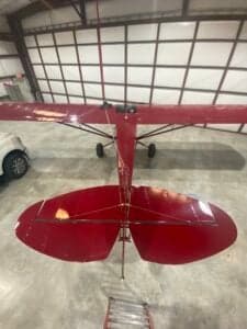 Top-down view of the tail section of a red Cubcrafters aircraft.