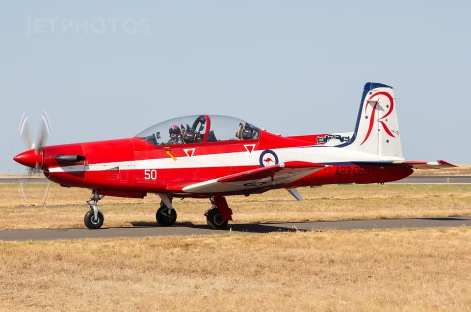 A23-050 aircraft on the ground with red and white paint scheme.