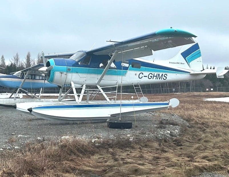 De Havilland DHC-2 Beaver floatplane in white and blue livery, parked on the ground.