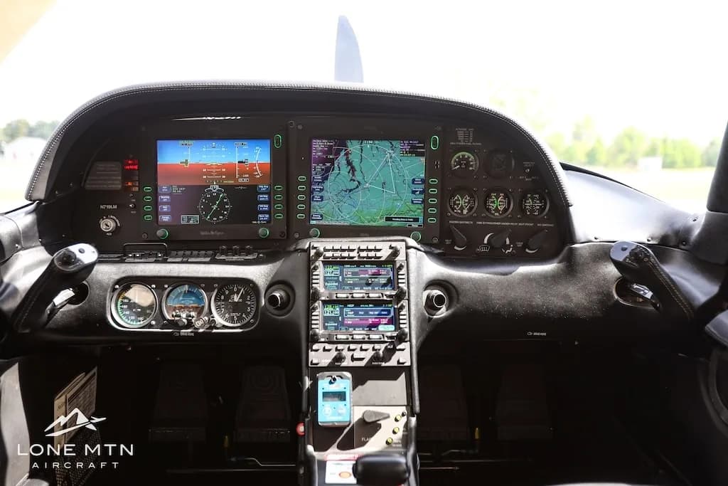 Close-up view of the modern glass cockpit with multiple screens and controls in a Cirrus SR22 aircraft.