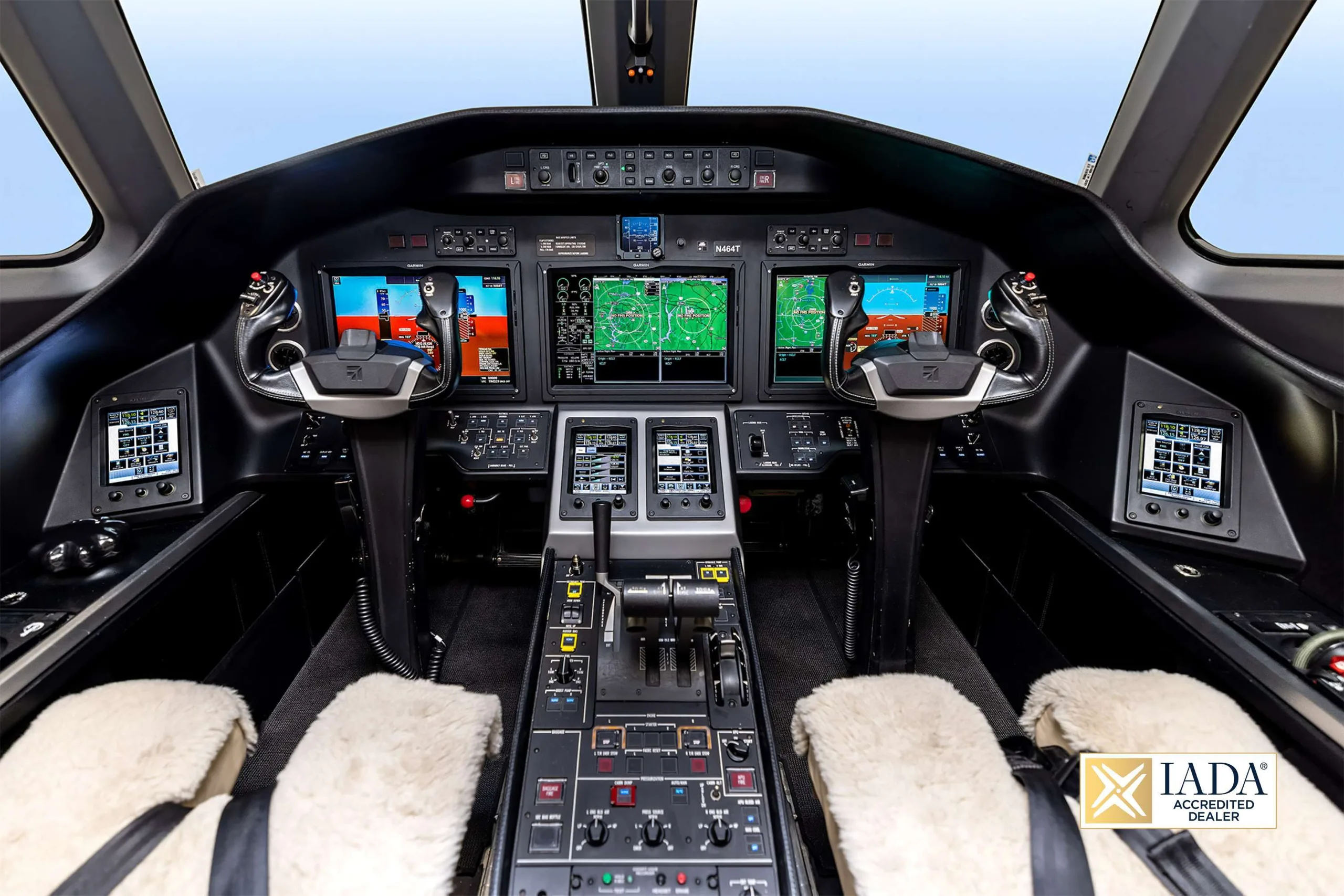 A wide view of the modern cockpit of the N464T business jet, featuring multiple digital displays.
