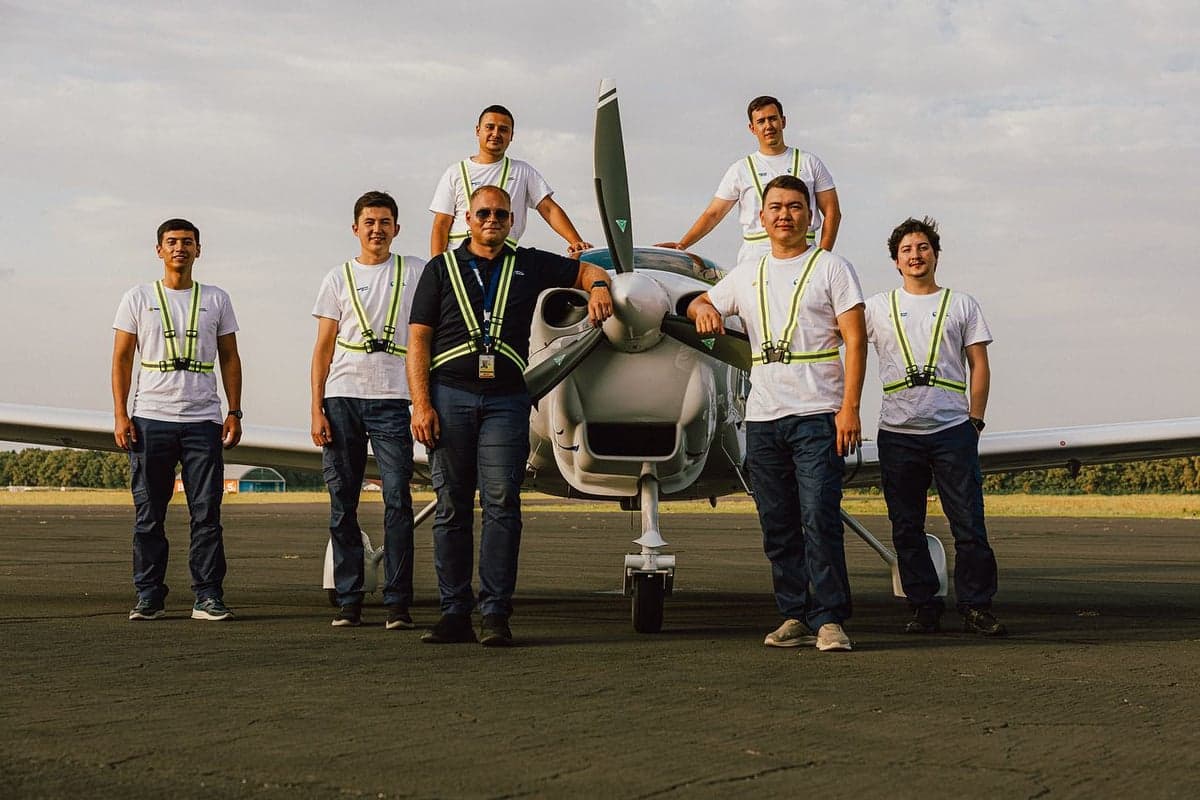 Group photo of people in front of a Diamond DA40 aircraft.