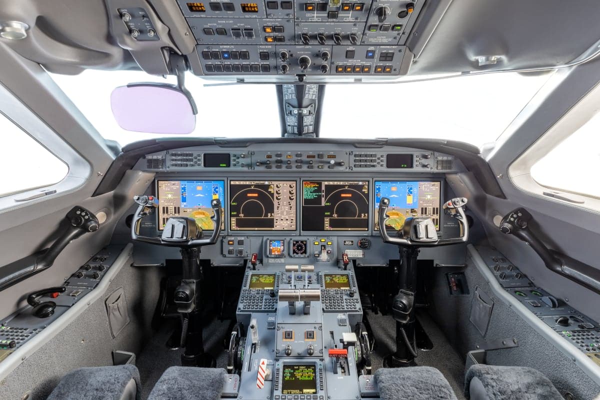 View of the aircraft cockpit with multiple displays and controls.