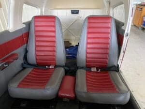 Rear seats of the aircraft cabin with red and gray upholstery.