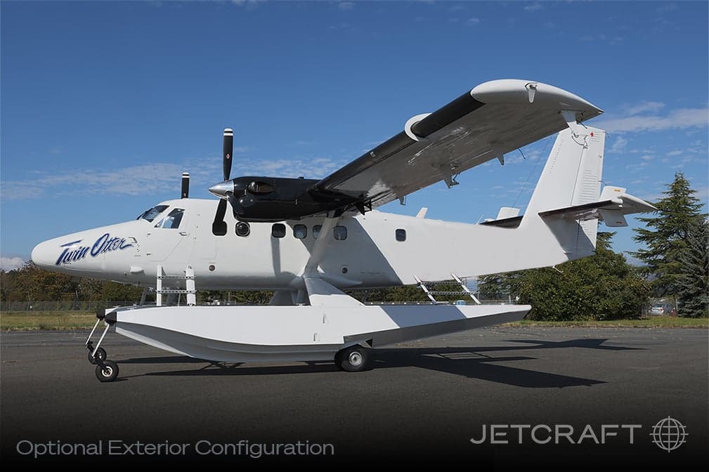Side view of a white Twin Otter seaplane on the water.