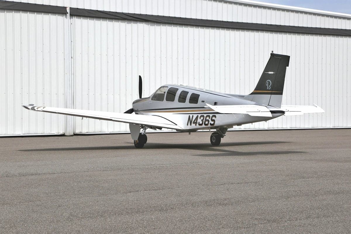 Side view of a silver and white Beechcraft Bonanza with tail number N436S.