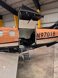 Close-up of the Pilatus PC-12 aircraft N970TB entrance with steps extended.