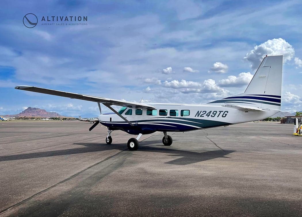 Cessna 208 Caravan, registration N249TG, parked on the tarmac with a control tower in the background.